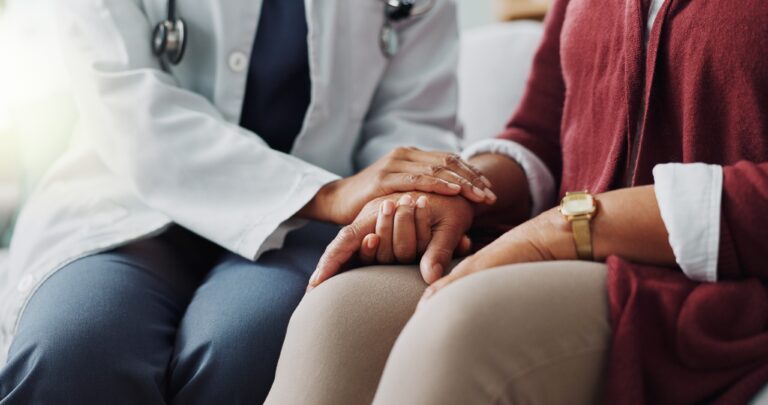 Closeup, hands or care as doctor, patient or healthcare consultation to trust, support or help. People, lab coat or touch as hope, faith or prayer in medical appointment to discuss retirement health.